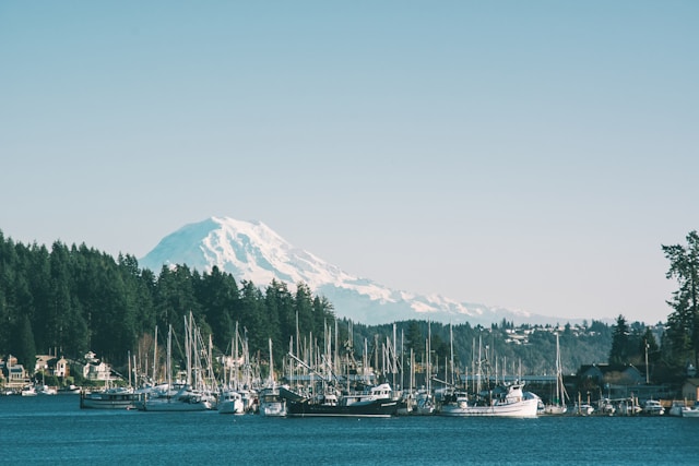 A woman walking along a shoreline at sunrise, evoking calm coastal care near Gig Harbor